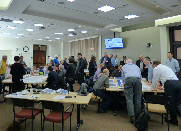 大约35人分别坐在Sound Transit委员会会议室内的各个会议桌旁，互相讨论并浏览着项目资料。 