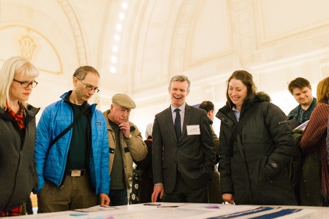 Photograph of community members looking at a project map with Sound Transit staff.